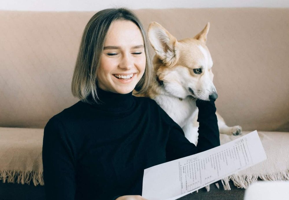 Corgi dog with woman working on her laptop at pet-friendly apartment raleigh -- pexels-nataliya-vaitkevich-6919719